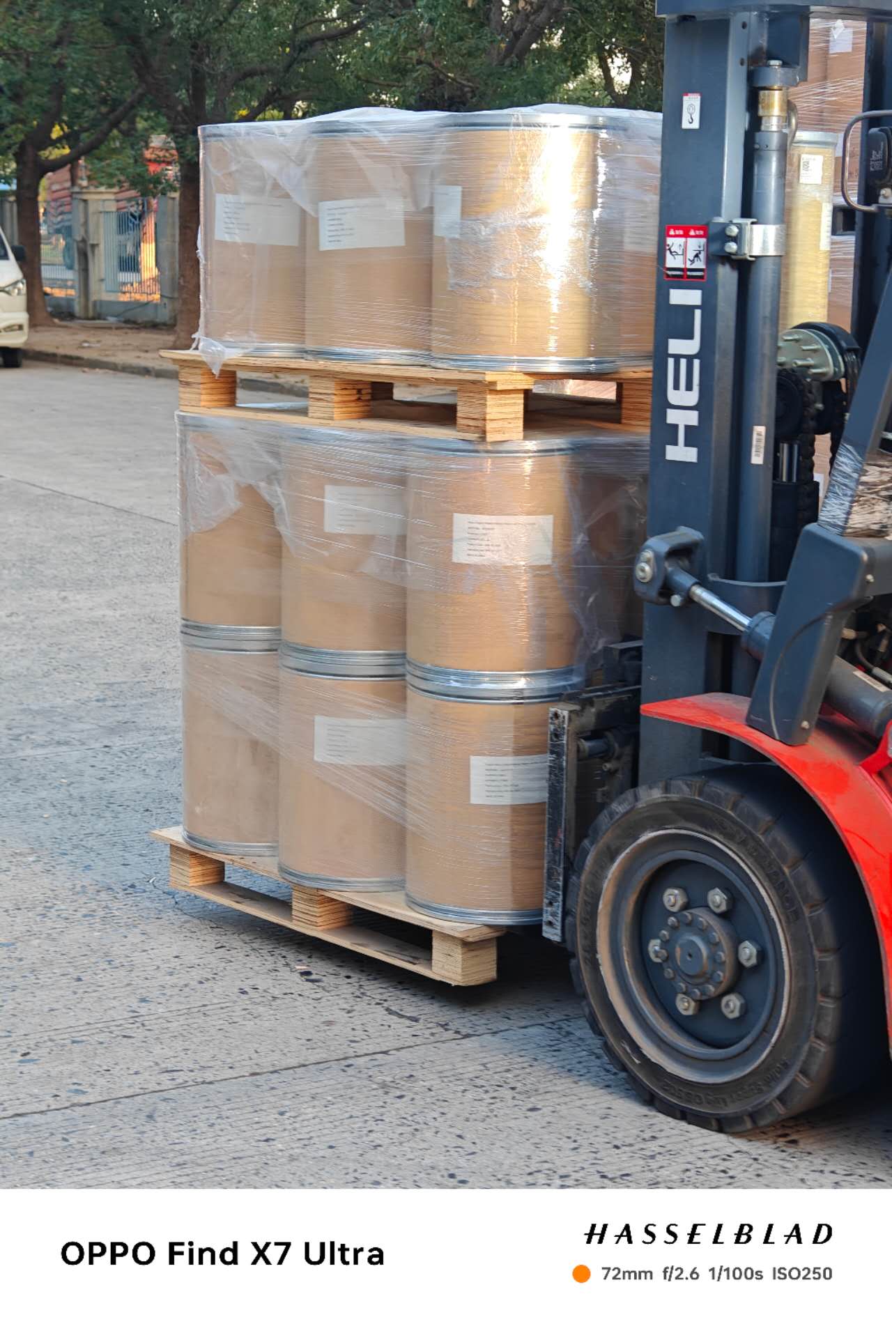 Wrapped fiber drums being transported by forklift